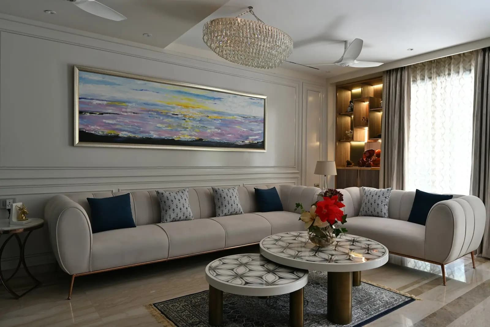 Bright living room with a grey sectional sofa and round marble coffee tables