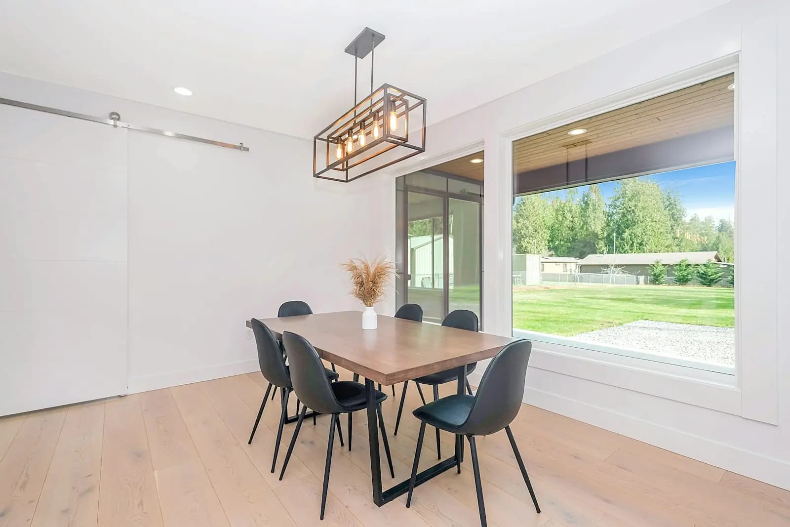 Minimal dining room with a large picture window onto a lawn